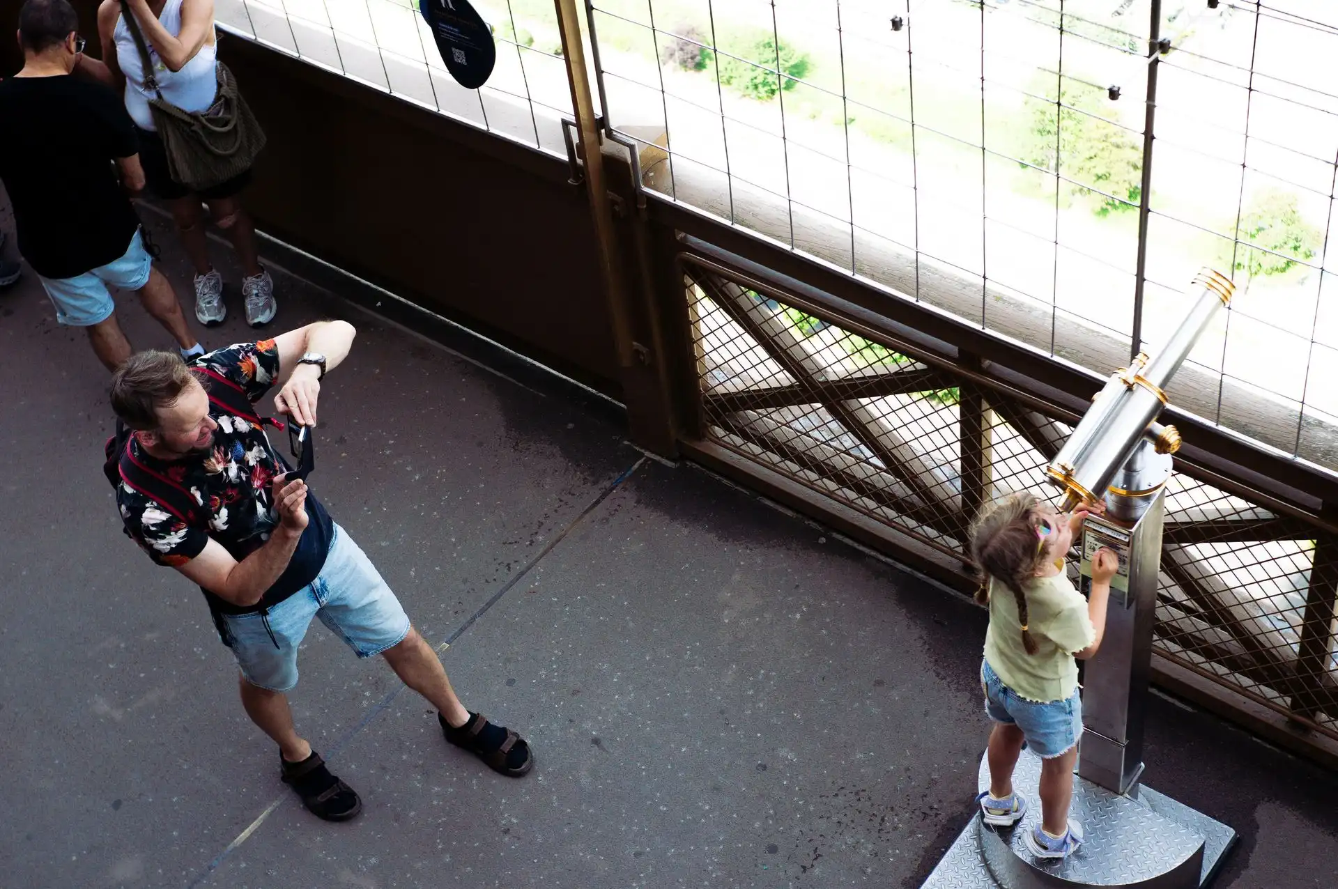 Visitors using a telescope on the Eiffel Tower observation deck Visitors using a telescope on the Eiffel Tower observation deck