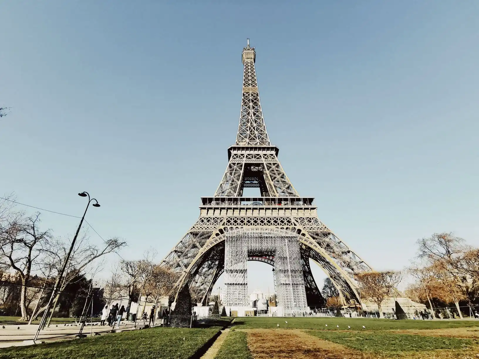 Low angle view of the Eiffel Tower against a blue Paris sky Low angle view of the Eiffel Tower against a blue Paris sky