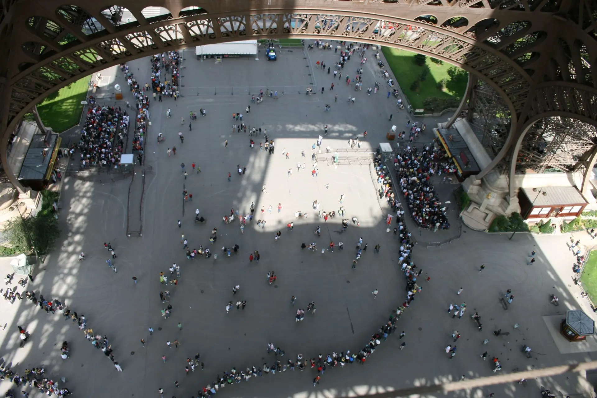 A long queue of visitors at the base of the Eiffel Tower